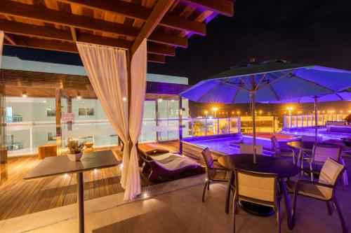a patio with tables and umbrellas at night at Vidam Hotel Aracaju - Transamerica Collection in Aracaju