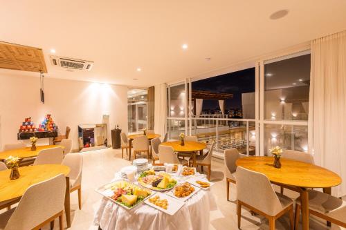 a restaurant with tables and chairs with food on them at Vidam Hotel Aracaju - Transamerica Collection in Aracaju