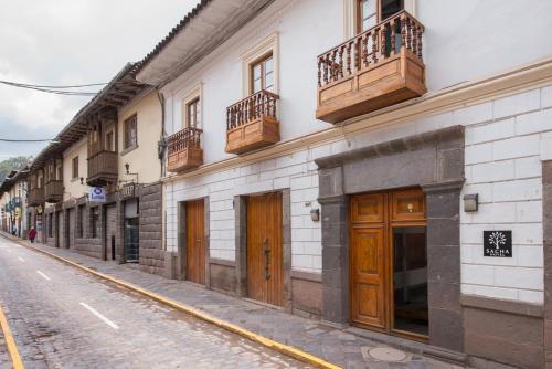een gebouw met houten deuren en balkons aan een straat bij SACHA Centric in Cuzco