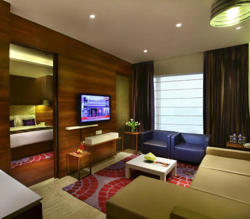 a living room with a couch and a bed at Park Plaza Shahdara in New Delhi