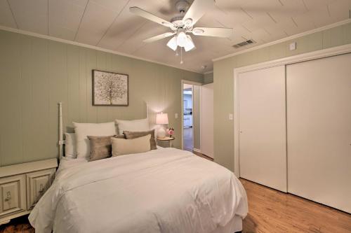 a bedroom with a white bed with a ceiling fan at Waterfront Getaway with Dock on Lake Hamilton! in Lake Hamilton