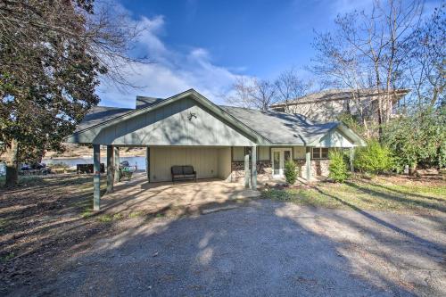 a small house with a garage in a yard at Waterfront Getaway with Dock on Lake Hamilton! in Lake Hamilton