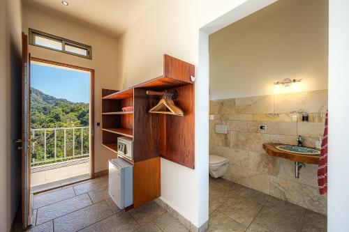 a bathroom with a sink and a toilet and a window at Casa Laureles in Bejuco