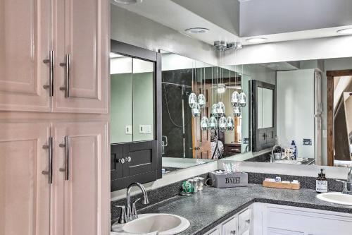 ein Badezimmer mit zwei Waschbecken und einem großen Spiegel in der Unterkunft 5-Acre Graceland Family Home in West Des Moines in West Des Moines