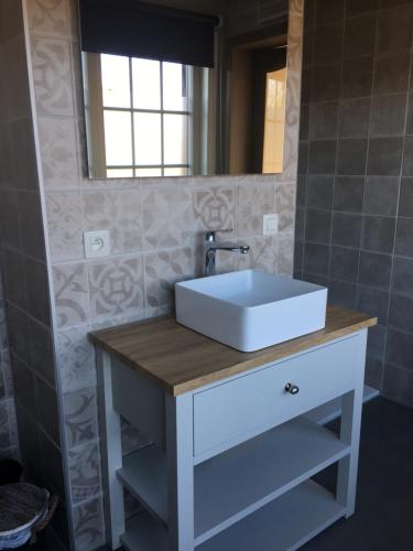 a bathroom with a white sink and a mirror at Le Sommelet in Somme-Leuze