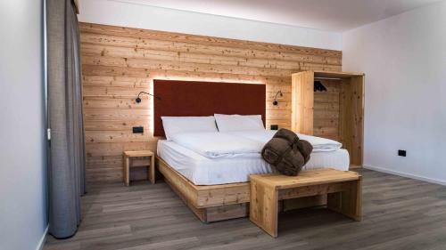 a bedroom with a white bed and a wooden wall at ALPS LOVER in Campodenno