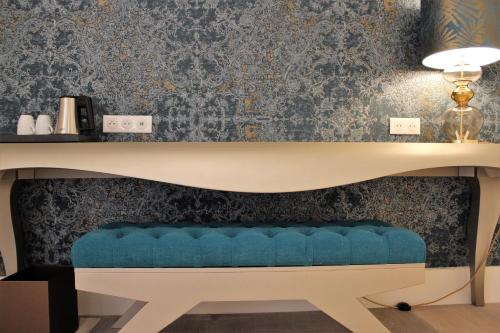 a desk with a blue bench under a desk at Hôtel Ginkgo - SPA Biloba in Quimper