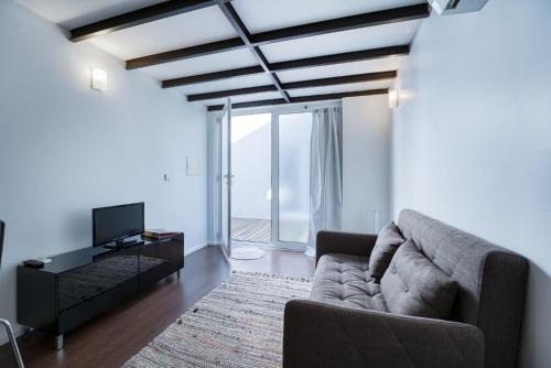 a living room with a couch and a tv at Fine Arts Studios by Olala Homes in Porto