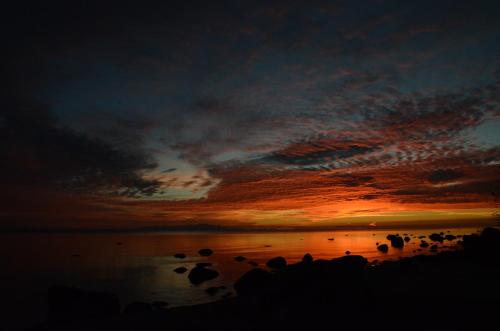 a sunset over a body of water with birds on it at Pilava in Roja
