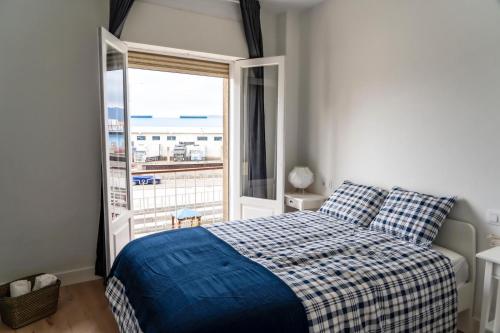 een slaapkamer met een bed en een groot raam bij Moderno-Dinámico in Vigo