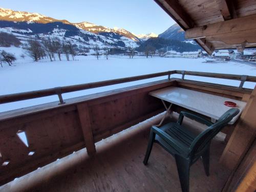 a table and a chair on the balcony of a cabin at Ferienhotel Alpenhof in Aurach bei Kitzbuhel