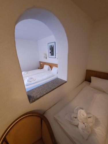 a bedroom with two beds and a mirror at Ferienhotel Alpenhof in Aurach bei Kitzbuhel