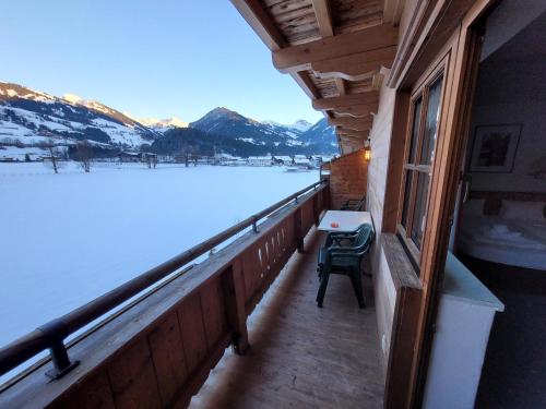 a balcony with a table and a view of a snow covered mountain at Ferienhotel Alpenhof in Aurach bei Kitzbuhel