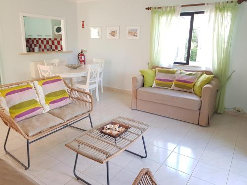 een woonkamer met een bank en een tafel bij Algarve Apartment Falésia in Albufeira