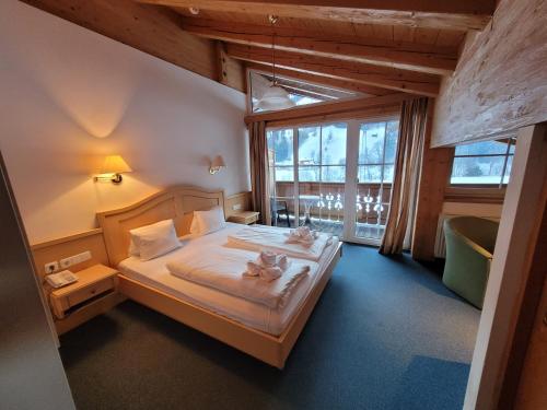 Un dormitorio con una cama con dos gatos. en Ferienhotel Alpenhof en Aurach bei Kitzbuhel