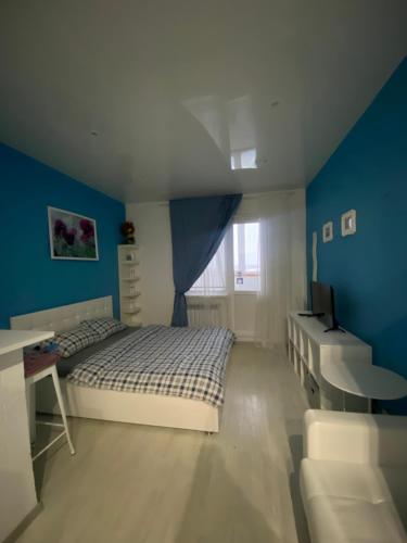 スルグトにあるApartment on Zakharovaの青い壁のベッドルーム1室(ベッド1台付)