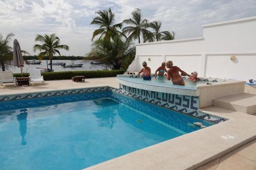 a group of people sitting in a swimming pool at Hôtel Katakalousse in Yembakana