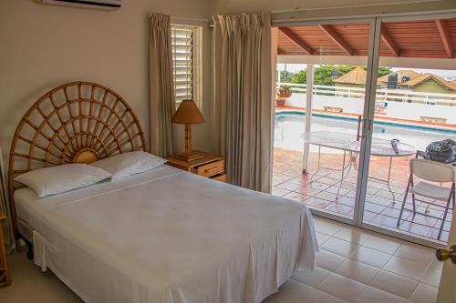 a bedroom with a bed and a balcony with a pool at The Whytehouse Villa in Montego Bay