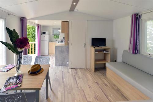 a living room with a couch and a table at Camping Au Coeur de Vendome in Vendôme