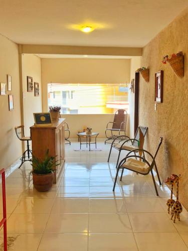 a living room with a table and chairs and a laptop at Estalagem e Restaurante Cantinho Bistrô in Alto Caparao