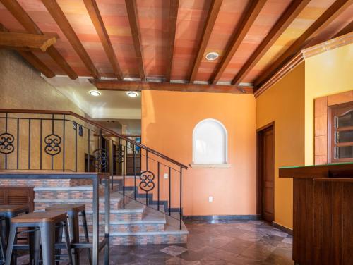 a dining room with orange walls and wooden ceilings at Hostal Nordés in Oaxaca City