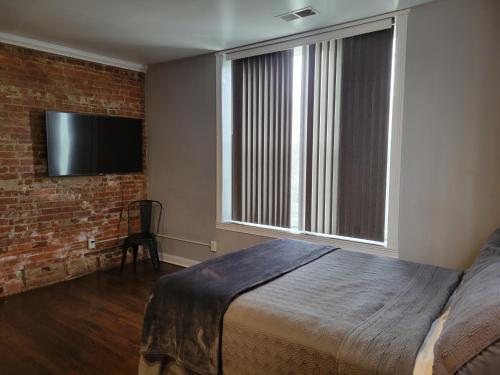 a bedroom with a bed and a brick wall at Modern style and comfort near UC in Cincinnati