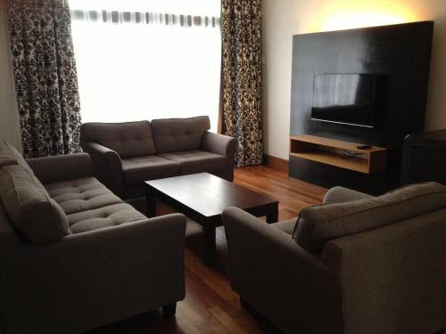 a living room with two couches and a television at Strawberry Park Resort in Cameron Highlands