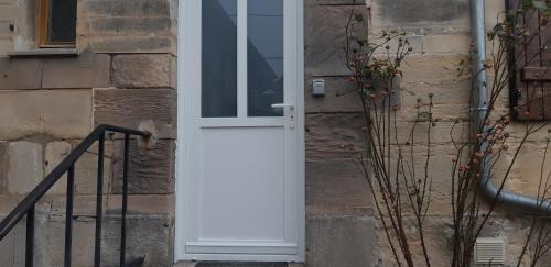 uma porta branca do lado de um edifício em John & Ghislaine em Donjeux