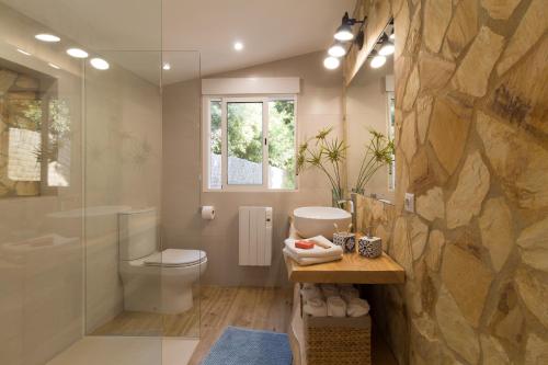 a bathroom with a toilet and a glass shower at CASA RURAL EL JARDI con Piscina, Jardin y Barbacoa in Arenys de Munt