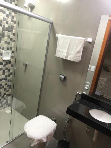 a bathroom with a shower and a toilet and a sink at Hotel Santa Maria in Pirenópolis