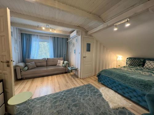 a bedroom with a bed and a couch in a room at Comfort Zone Ostróda BLUE in Grabinek