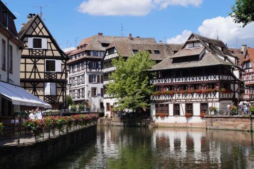 a group of buildings next to a river at Le Clos d'Azel MAISON D'HOTES in Flexbourg