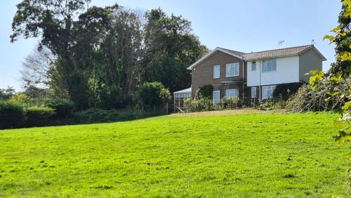 een huis op een heuvel met een groen veld bij Summerfields House in Hastings