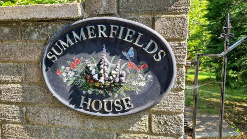 una señal para una casa de campo en una pared de ladrillo en Summerfields House en Hastings