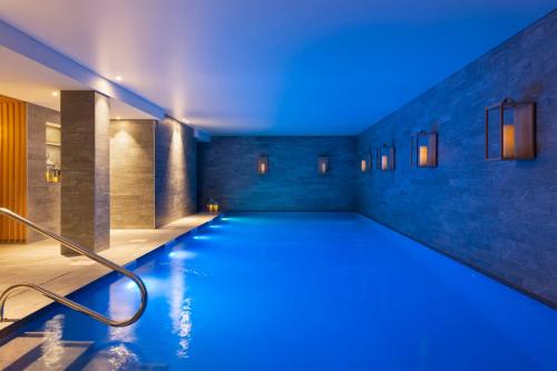 - une piscine avec des lumières bleues dans un bâtiment dans l'établissement RockyPop Flaine Appartements & Spa, à Flaine