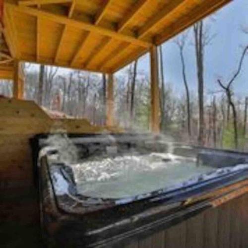 a hot tub in a building with at Mountain Hideaway with Hot Tub & Fire Pit in Mineral Bluff