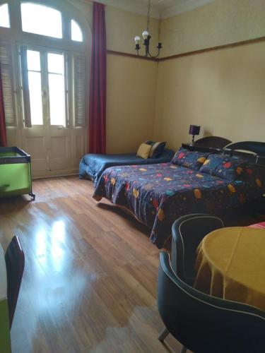 1 dormitorio con 2 camas, mesa y sillas en Blanca Rosa Valparaiso B&B en Valparaíso