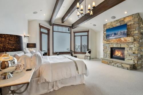 a bedroom with a large bed and a fireplace at Deer Hollow Chalet in Park City