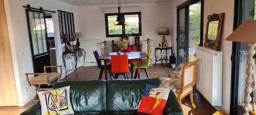 un salon avec un canapé vert et une table dans l'établissement VILLA LES COQUELICOTS, à Gujan-Mestras