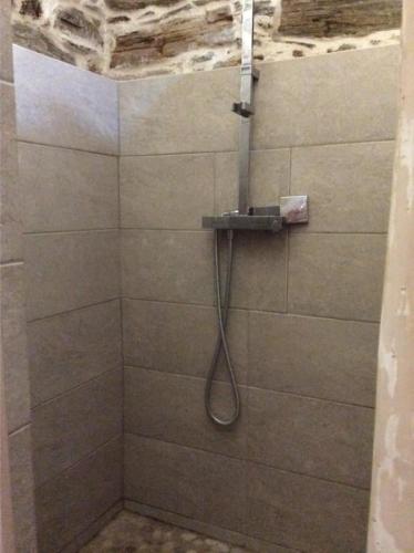 a shower with a hose attached to a wall at Bergerie tout confort L'immortelle in Saint-Florent