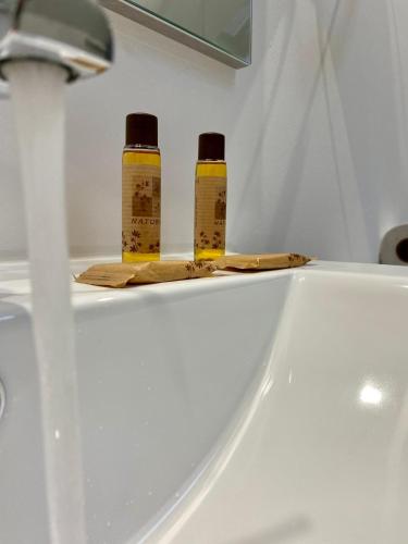 two bottles of mustard sitting on top of a sink at Casa de São Marcos in Manteigas