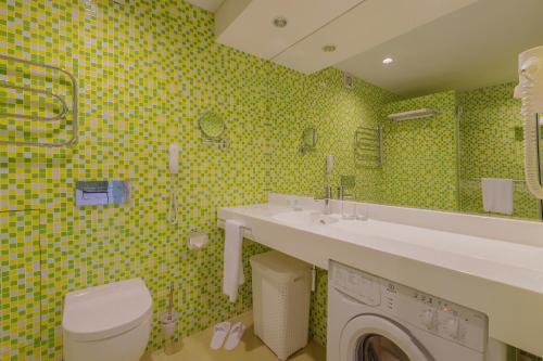 a bathroom with a sink and a washing machine at Dom Hotel Apart in Krasnoyarsk