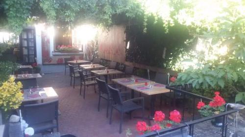 a restaurant with tables and chairs and flowers at Hôtel Restaurant Aux Deux Roses in Neuf-Brisach