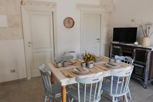 una sala da pranzo con tavolo e sedie in legno di Trullo La chicca della valle a Cisternino