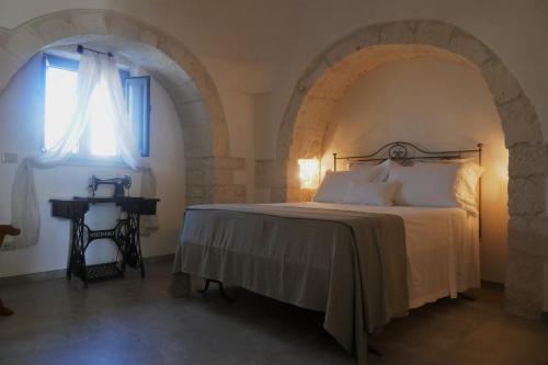 a bedroom with a bed and a window at Trullo La chicca della valle in Cisternino