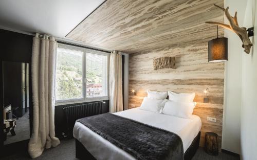 a hotel room with a bed and a window at Rock Noir & Spa in La Salle-les-Alpes