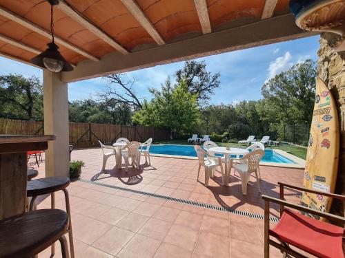 a patio with a table and chairs and a pool at Harveys Homestay - Adults only in Mieres