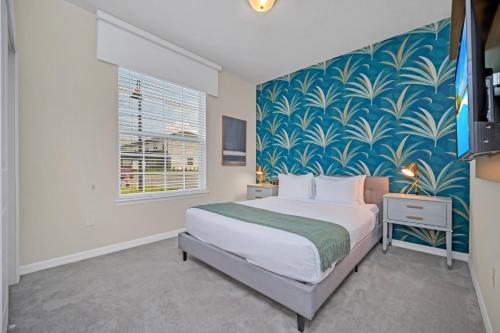a bedroom with a bed with a blue and white wallpaper at Free Waterpark Private Splash Pool Near Disney in Davenport