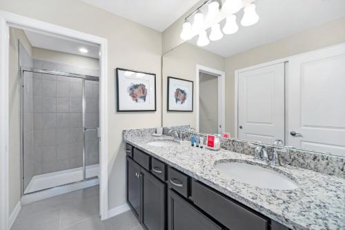 a bathroom with two sinks and a shower at Free Waterpark Private Splash Pool Near Disney in Davenport