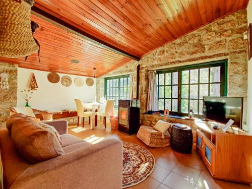 a living room with a couch and a tv and a table at Neiva River House - Azenha Next to the River in Esposende